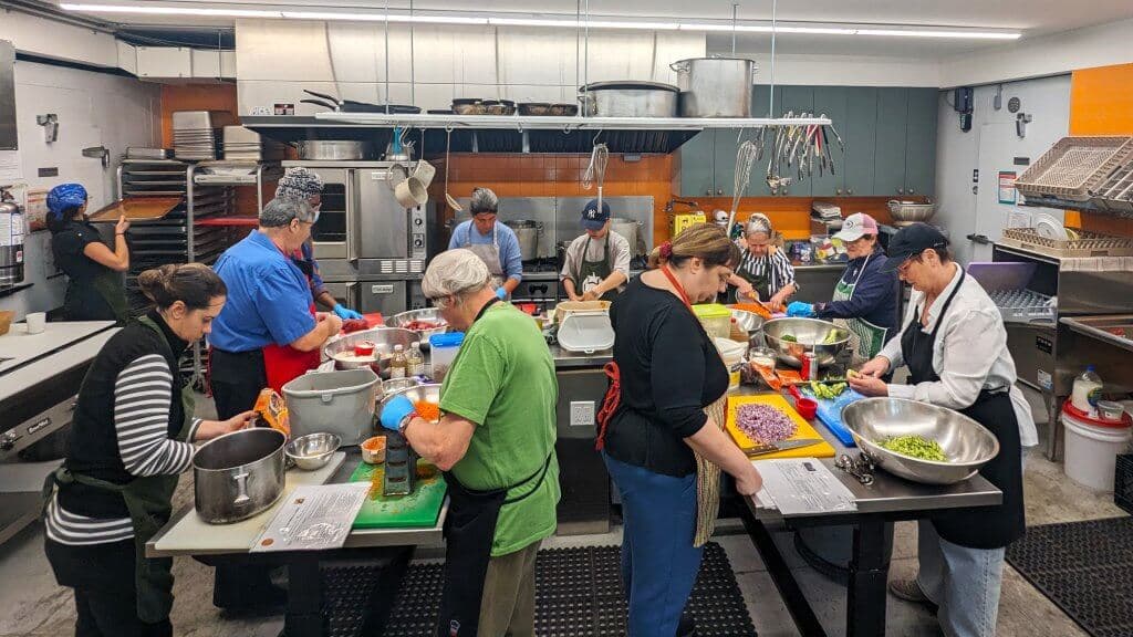 Volunteers cooking together in a community kitchen